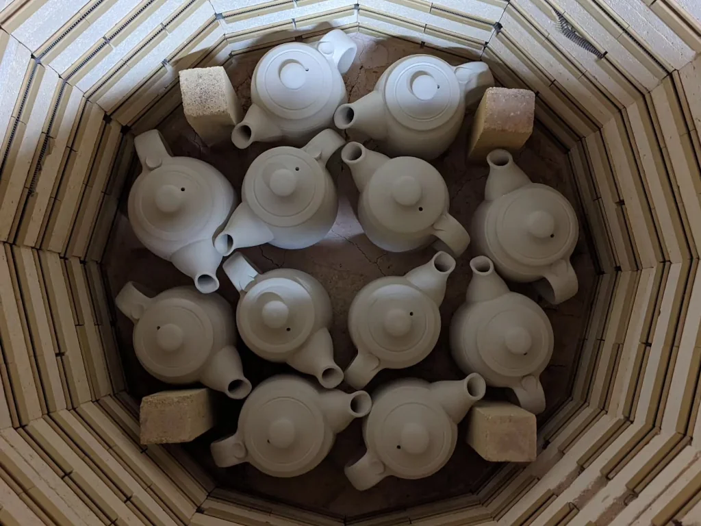 Teapots loaded inside a kiln before firing