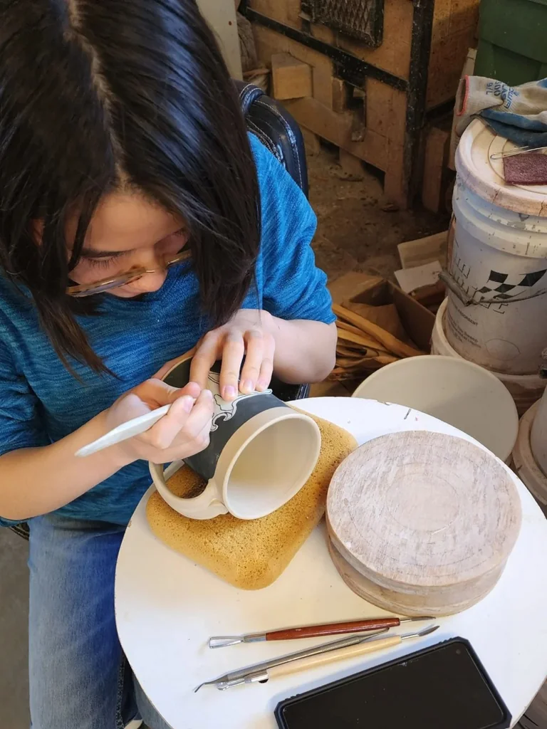 Carving a marine design into a mug
